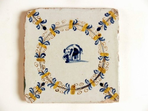 Tegel met blauwwit decor van een olifant in een polychrome aigrettekrans